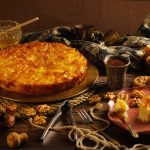 koláč na stole s medom, orechmi a keksami