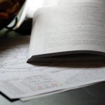 otvorená kniha s perom a astrologický rádix na papieri