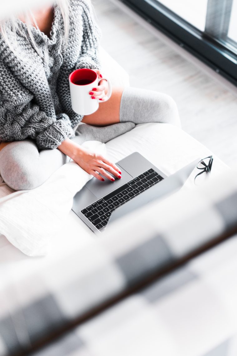 woman working from her bed with laptop